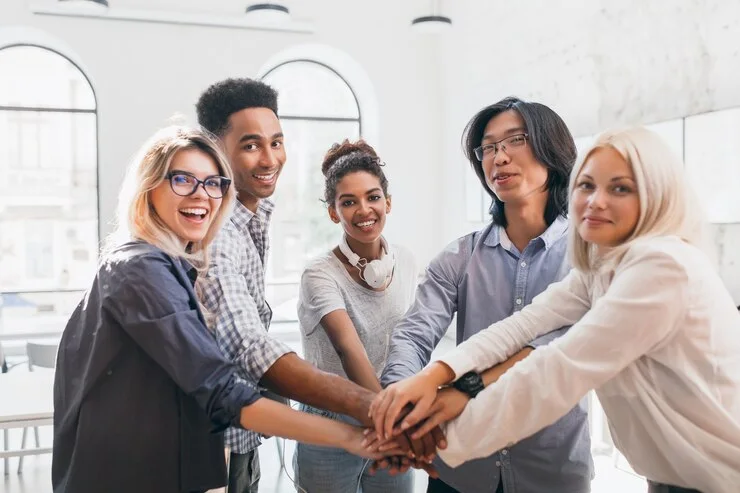 Equipe de colaboradores reunida com as mãos ao centro